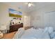 Cozy bedroom showcasing a mounted TV, ceiling fan, dresser, and a comfy bed with decorative pillows at 603 Pinehurst Ct, Kissimmee, FL 34758