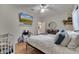 Cozy bedroom showcasing a mounted TV, ceiling fan, a wooden dresser, and a bed with decorative pillows at 603 Pinehurst Ct, Kissimmee, FL 34758