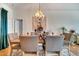 Cozy dining area showcasing a modern chandelier, a table set for six, and hardwood flooring at 603 Pinehurst Ct, Kissimmee, FL 34758