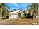 Charming single-story home featuring lush landscaping, a two-car garage, and solar panels at 603 Pinehurst Ct, Kissimmee, FL 34758