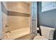 A clean bathroom with a tub and shower combination, featuring modern tiling and fixtures at 1711 Laurel Glen Pl, Lakeland, FL 33803