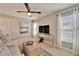 Comfortable bonus room with a ceiling fan, TV, ottoman, and bright natural light from the windows at 1711 Laurel Glen Pl, Lakeland, FL 33803