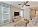 Comfortable bonus room with a ceiling fan, TV, ottoman, and bright natural light from the windows at 1711 Laurel Glen Pl, Lakeland, FL 33803