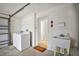 A combined laundry room and garage space with washer, dryer, and utility sink at 2378 Ridgeway Ct, The Villages, FL 32162