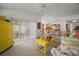 The light-filled living room showcases floral furniture, yellow accents, and seamless access to the patio at 2378 Ridgeway Ct, The Villages, FL 32162
