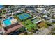 Aerial view of a vibrant community featuring a pool, tennis courts, mini golf, and waterfront living at 9000 Us Highway 192 # 242, Clermont, FL 34714