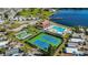 Aerial view of community featuring pool, clubhouse, tennis courts, and marina on waterfront at 9000 Us Highway 192 # 242, Clermont, FL 34714