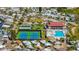 An aerial view showcases the active community with a pool, clubhouse, tennis courts, and beautiful landscaping at 9000 Us Highway 192 # 242, Clermont, FL 34714