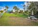 Spacious backyard with lush grass, a stone picnic table, and shade trees creating a peaceful retreat at 9000 Us Highway 192 # 242, Clermont, FL 34714
