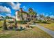 Clubhouse exterior with manicured landscaping, a bench, and palm trees offering an inviting community gathering space at 9000 Us Highway 192 # 242, Clermont, FL 34714