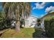 Charming white cottage with lush landscaping, stairway entry, and a tropical palm tree at 9000 Us Highway 192 # 242, Clermont, FL 34714