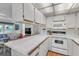The kitchen is efficiently designed with white appliances, countertops, cabinets and wood-look flooring at 9000 Us Highway 192 # 242, Clermont, FL 34714