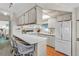 Well-lit kitchen with white cabinetry, modern appliances, and a breakfast bar with wicker stools at 9000 Us Highway 192 # 242, Clermont, FL 34714