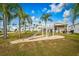 Community playground with a slide and sandy area surrounded by lush green grass and homes under a clear sky at 9000 Us Highway 192 # 242, Clermont, FL 34714