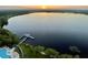 Sunrise aerial view of the property overlooking the lake, swimming pool, and the dock at 13427 Blue Heron Beach Dr # 2106, Orlando, FL 32821