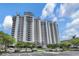 Multi-story condo with stacked balconies, parking, and landscaped greenery under a partly cloudy sky at 13427 Blue Heron Beach Dr # 2106, Orlando, FL 32821