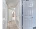 Bright hallway featuring tile flooring, white doors, and access to the bathroom and other rooms in the home at 2735 N Poinciana Blvd # 103, Kissimmee, FL 34746