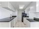 Bright kitchen with white cabinets, black appliances, and tile flooring at 2735 N Poinciana Blvd # 103, Kissimmee, FL 34746