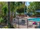 Community pool featuring a black fence, lounge chairs and tropical landscaping at 2735 N Poinciana Blvd # 103, Kissimmee, FL 34746