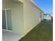 Angled view of house exterior featuring sliding glass door, small window, and a trash can at 357 Summershore Dr, Auburndale, FL 33823