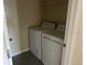 This laundry room has a washer and dryer with overhead shelving at 357 Summershore Dr, Auburndale, FL 33823