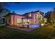 A luxurious backyard featuring a modern home, pool, fire pit, and comfortable lounge area at 1691 Chestnut Ave, Winter Park, FL 32789