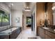 Well-lit bathroom with a modern tub, sleek vanity, and marble flooring at 1691 Chestnut Ave, Winter Park, FL 32789