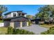 Stunning two-story home with a stone and dark wood facade, an attached garage, and a paved driveway at 1691 Chestnut Ave, Winter Park, FL 32789