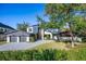 Beautiful modern two-story home with a manicured lawn, stone accents, and a spacious three-car garage at 1691 Chestnut Ave, Winter Park, FL 32789