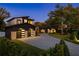A modern home featuring a stone and dark wood facade, an attached garage, and a paved driveway at 1691 Chestnut Ave, Winter Park, FL 32789