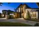 Modern two-story home featuring manicured landscaping and an inviting paved driveway and walkway, lit for evening at 1691 Chestnut Ave, Winter Park, FL 32789