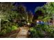 Charming fire pit area at night surrounded by lush landscaping creating a cozy outdoor retreat at 1691 Chestnut Ave, Winter Park, FL 32789