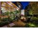 Inviting fire pit area with comfortable seating, enhanced by landscape lighting and lush tropical foliage at 1691 Chestnut Ave, Winter Park, FL 32789