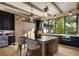 Modern kitchen boasts a large island, wooden beams, black cabinets, and an abundance of natural light from the windows at 1691 Chestnut Ave, Winter Park, FL 32789
