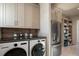 Bright laundry room with modern washer, dryer, stainless steel refrigerator and organized pantry at 1691 Chestnut Ave, Winter Park, FL 32789