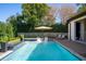 Inviting pool area with sun loungers, a fire feature, and a lush green backdrop for relaxing outdoors at 1691 Chestnut Ave, Winter Park, FL 32789