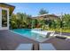 Serene pool view featuring in-pool seating, an umbrella for shade, and well-manicured landscaping at 1691 Chestnut Ave, Winter Park, FL 32789