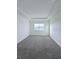 Bright, carpeted bedroom with tray ceiling and a large window offering plenty of natural light at 3842 Knotty Pine St, St Cloud, FL 34772