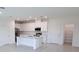 Bright, open-concept kitchen with white cabinets, modern appliances, and a large island for meal preparation at 3842 Knotty Pine St, St Cloud, FL 34772