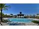 Community pool area surrounded by palm trees, featuring a covered gazebo and lounge chairs at 3842 Knotty Pine St, St Cloud, FL 34772