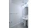 Clean and modern powder room with pedestal sink, round mirror, and neutral color palette at 3842 Knotty Pine St, St Cloud, FL 34772