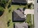 Aerial view of a well-maintained home with a landscaped yard and a driveway, nestled among mature trees at 584 Aldenham Ln, Ormond Beach, FL 32174