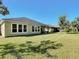 Back exterior shows the expansive lawn and covered patio, providing outdoor entertainment and relaxation at 584 Aldenham Ln, Ormond Beach, FL 32174