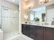 Modern bathroom featuring double sinks, a large mirror, and a glass-enclosed shower at 584 Aldenham Ln, Ormond Beach, FL 32174