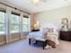 Bright bedroom featuring large windows, plush carpet, and a stylish white wooden headboard at 584 Aldenham Ln, Ormond Beach, FL 32174