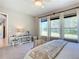 Bright bedroom with windows overlooking a lush backyard, chair, and decorative table at 584 Aldenham Ln, Ormond Beach, FL 32174