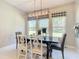 Bright dining room with modern lighting, large windows, and a table set for six at 584 Aldenham Ln, Ormond Beach, FL 32174