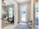 Bright foyer with decorative front door, tile flooring, and adjacent sitting area with large windows at 584 Aldenham Ln, Ormond Beach, FL 32174