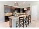 Spacious kitchen island with dark cabinets and seating for four at 584 Aldenham Ln, Ormond Beach, FL 32174