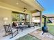 Covered patio features comfortable seating area with ceiling fan and fire pit, perfect for outdoor relaxation at 584 Aldenham Ln, Ormond Beach, FL 32174